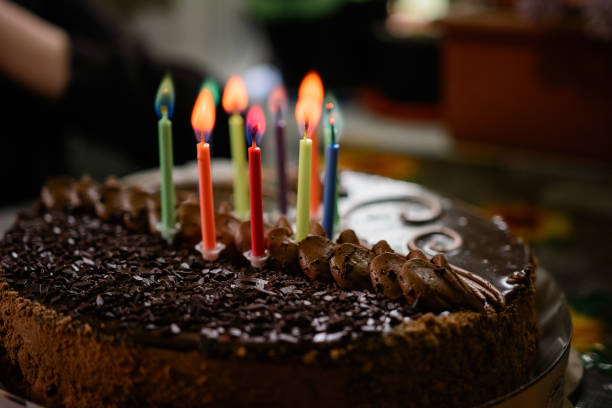 istock Chocolate birthday cake with candles, lighting candles on the cake. 1310468574