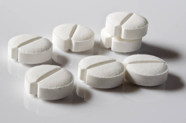 close-up de pílulas brancas em fundo branco. sete comprimidos com entalhes. - painkiller vitamin pill full frame macro - fotografias e filmes do acervo