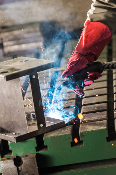 istock hand welder in red leather mitten work on the details 1310474988