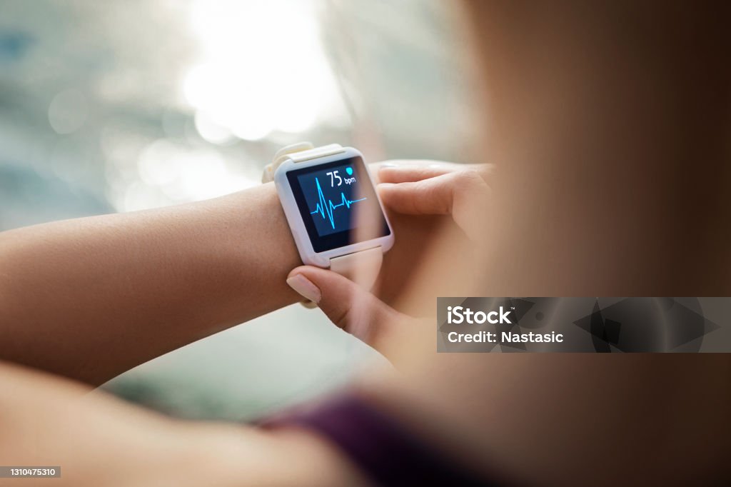 Woman Looking At Her Smart Watch for a pulse trace Sporty Woman Looking At Her Smart Watch Healthcare And Medicine Stock Photo