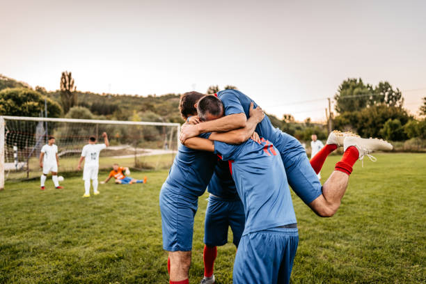 Soccer players  celebrating a goal Happy soccer players celebrating a goal scoring or victory. soccer soccer ball kicking adult stock pictures, royalty-free photos & images