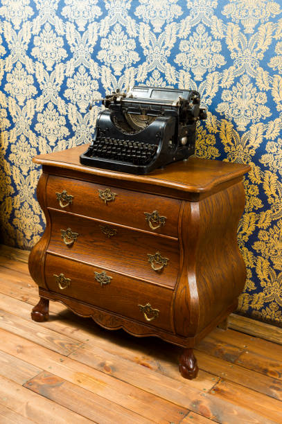 istock Old vintage typewriter on the wooden bureau 1310476735