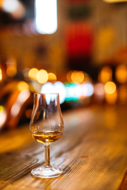 Glass of whiskey on bar counter.