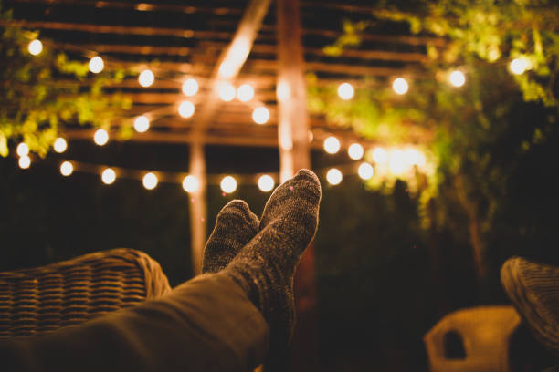 Cozy Patio Atmosphere Man relaxing at his backyard patio light strings stock pictures, royalty-free photos & images