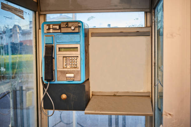 antigua cabina telefónica instalada en el centro de una ciudad - telephone cabin fotografías e imágenes de stock