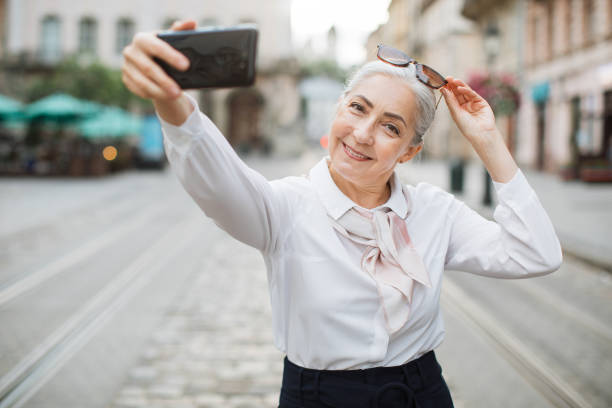 istock Female pensioner using smartphone for taking selfie 1310485549