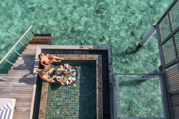 vista de drones de la pareja disfrutando de un desayuno flotante en un hotel de lujo - honeymoon beach swimming pool couple fotografías e imágenes de stock