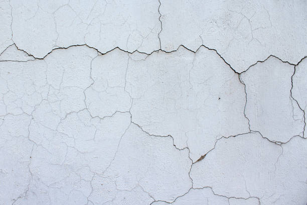 istock Close up of textured racked white old wall background 1310485703