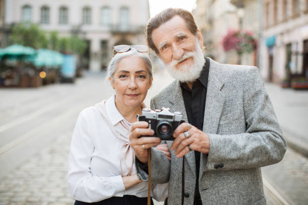 istock Mature couple posing outdoors with retro photo camera 1310485714
