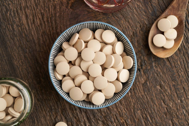 Brewer's yeast tablets in a bowl - nutritional supplement Brewer's yeast tablets in a bowl - nutritional supplement rich in vitamin B bakers yeast stock pictures, royalty-free photos & images