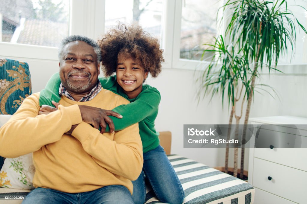 Portrait of a happy girl and her grandpa Portrait of the African American teenage girl enjoying at home with grandpa. Grandfather Stock Photo