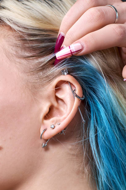 boucle d’oreille de goujon de cerf sur la fermeture d’oreille de femme vers le haut. perçant - perching photos et images de collection