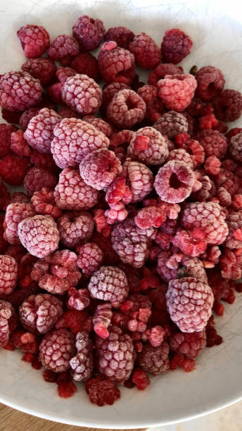 istock Image of defrosting frozen raspberry summer fruit in a white bowl, elevated view 1310493395
