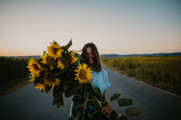 istock Female and sunflowers in sunset 1310494399