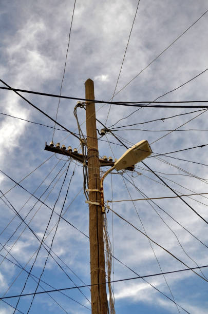 Complex Telecommunications Complex communications - multiple wires leading in all directions from a telegraph pole. utility pole with power lines close up stock pictures, royalty-free photos & images