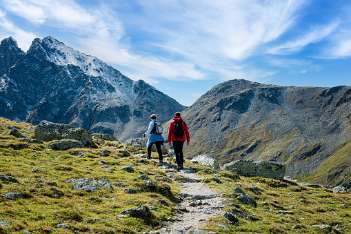 Two hikers on the Muragl valley in the area St.Moritz. Panoramic view.
