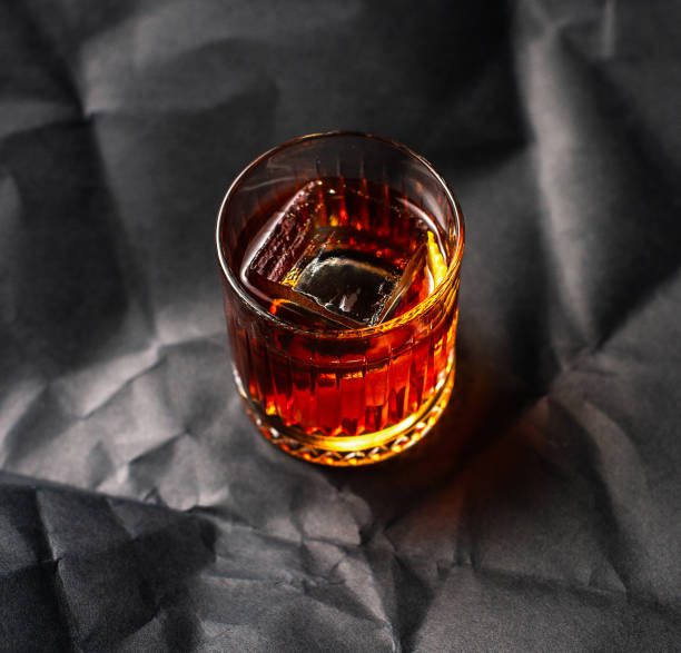 istock Whiskey with ice into glass on dark background 1310498877