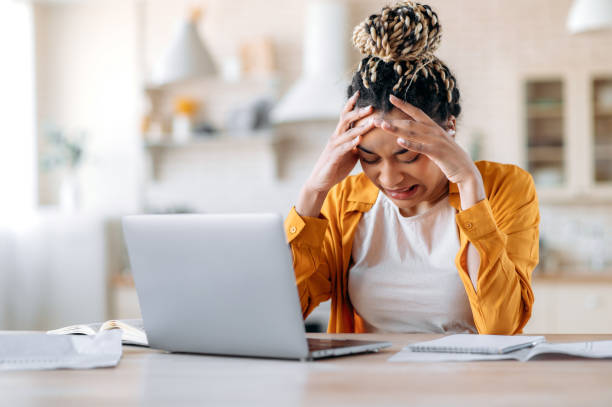 istock Upset sad frustrated african american girl, student, manager or freelancer working or studying at home with laptop, stressed at work, overworked, crying, failed a deal, holding her head with her hands 1310501833