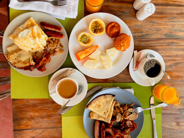 istock Breakfast in the hotel restaurant on the table with scrambled eggs, bacon, pancakes, sausages, mushrooms, coffee, juice and fruit pineapple, papaya, passion fruit 1310503633