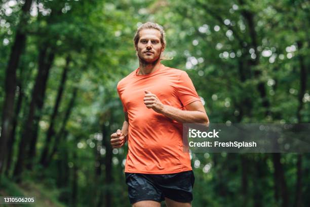 Young Caucasian Sportsman Running In The Forest Stock Photo - Download Image Now - Men, Running, Jogging