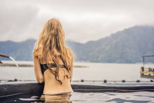 geothermal spa. woman relaxing in hot spring pool against the lake. hot springs concept - 2546 imagens e fotografias de stock