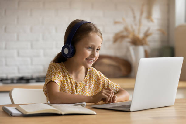 istock Happy little girl study online on computer at home 1310511794