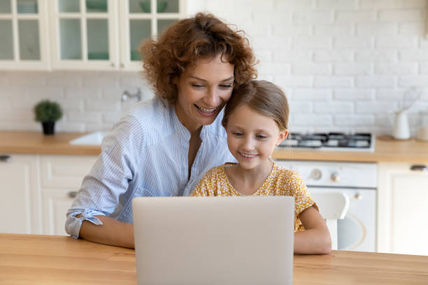 istock Smiling young mom and small daughter work on laptop 1310511827