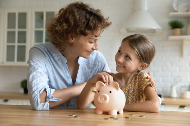 istock Happy young mom and daughter saving for future 1310511840