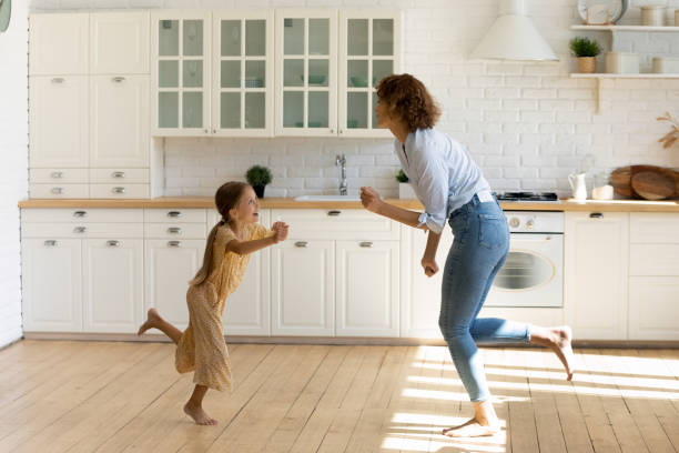 istock Happy young mom and little daughter dance in kitchen 1310511846