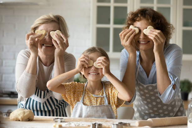 portrait of happy three generations of women baking in kitchen - grandmother cooking baking family imagens e fotografias de stock
