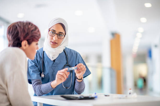 kobieta muzułmański lekarz pokazano pacjenta z cukrzycą wstrzykiwacz insuliny - diabetes doctor zdjęcia i obrazy z banku zdjęć