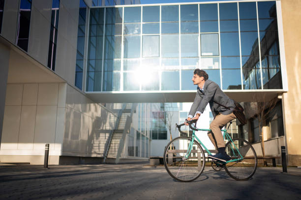 istock Side view of a young businessman riding a bicycle 1310516169