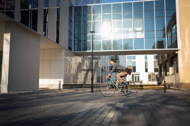 istock Side view of a young businessman riding a bicycle 1310516172