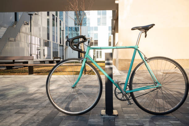 bicyclette garée dans le stationnement des immeubles de bureaux - parking vélo photos et images de collection