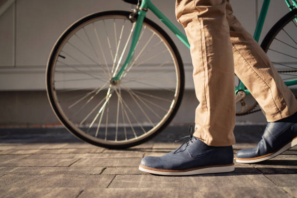 istock Side view of an unrecognizable man in leather shoes with a bicycle 1310516232
