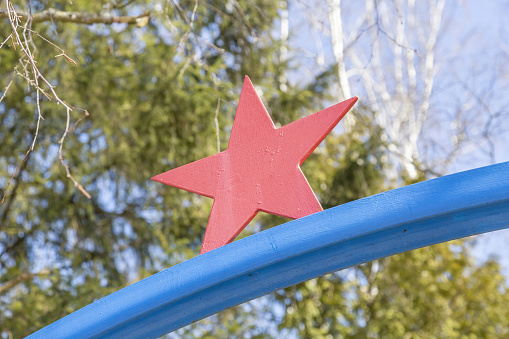 Old iron red star on a natural background. Symbol of communism and the Soviet Union