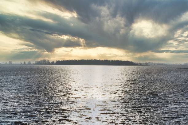 istock Sunset over a silver colored sea, colorful clouds and sun 1310518658