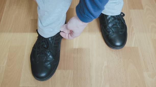 istock Man in a blue jacket and white trousers adjusts his pant leg 1310519308