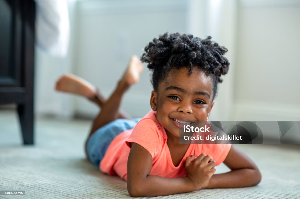 Cute little African American girl smiling and laughing. African American girl smiling and laughing at home. Child Stock Photo