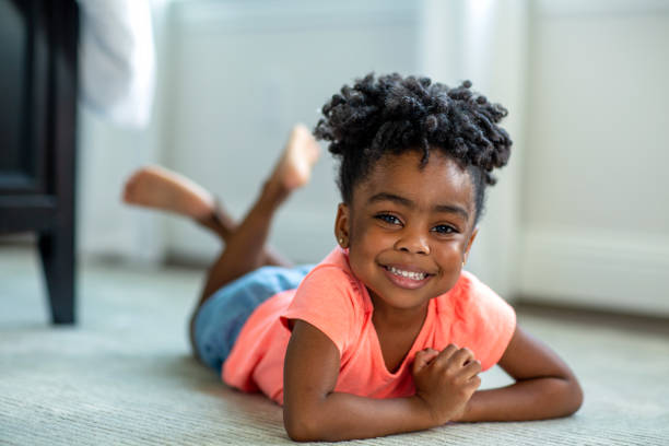 Cute little African American girl smiling and laughing. African American girl smiling and laughing at home. preschool student stock pictures, royalty-free photos & images