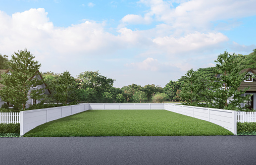 Vacant land a green lawn with a white fence around in front of the road the background is natural 3d render