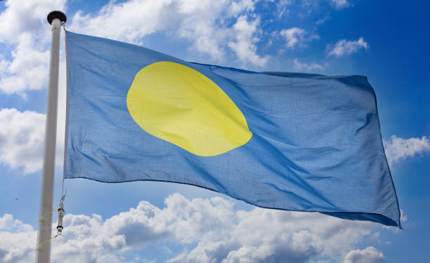 istock Palau flag waving against blue cloudy sky 1310534118