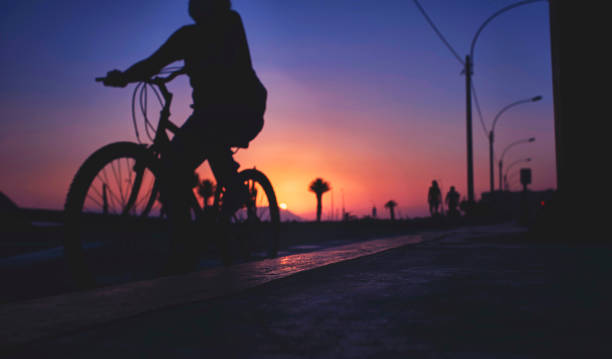 istock Silhouette riding bicycle at sunset. Selective focus. Abstract Silhouette background concept. 1310536379