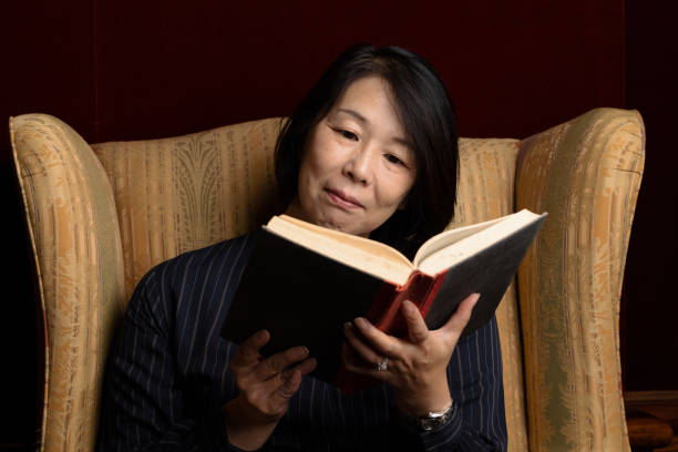 istock Smiling woman sitting down with a hardcover book 1310536524