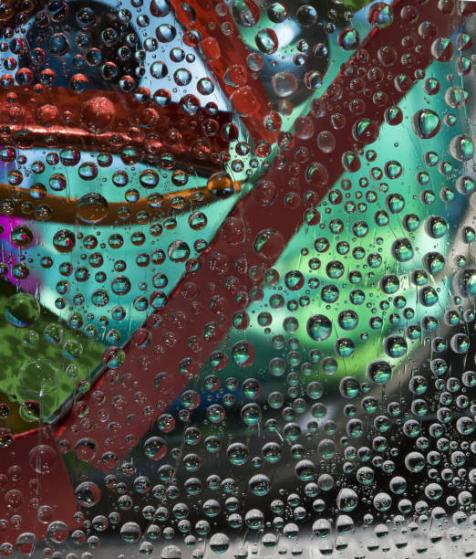 istock Translucent drops of water fall down against the blue- green background with multicolored geometric figures. 1310537111