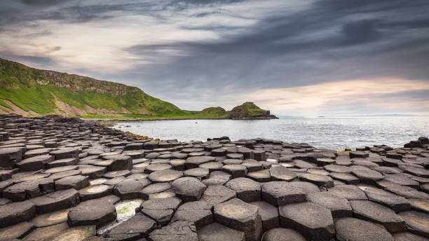 Giant's Causeway Sunset Panorama Northern Ireland Giant's Causeway Scenic Landscape Sunset Panorama under moody twilight skyscpe. Ultrawideangle 10mm Panorama Landscape Shot. Giants Causeway, Antrim County, Northern Ireland, United Kingdom, Northern Europe, Europe giants causeway stock pictures, royalty-free photos & images