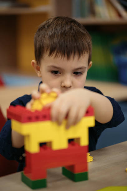 istock Little kid boy having fun with building and creating robot. 1310540637
