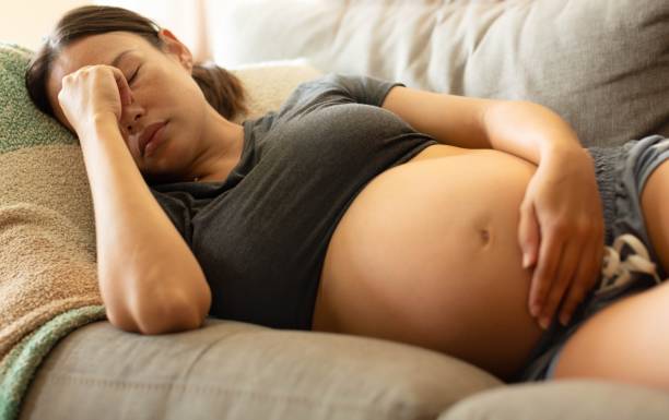 A tired stressed pregnant woman resting at home. stock photo
