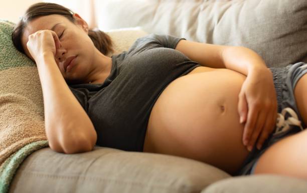 a tired stressed pregnant woman resting at home. - baby lying down sleeping asian ethnicity imagens e fotografias de stock