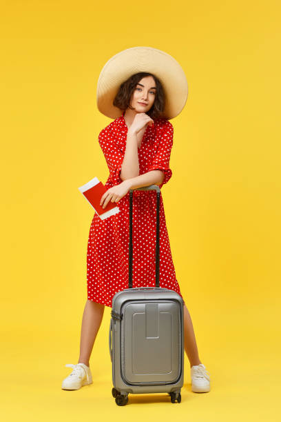istock woman with suitcase going traveling on yellow background. 1310559453